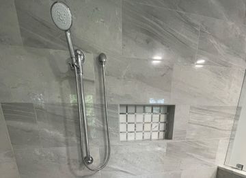hand-held shower head with a title shower wall