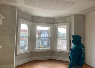 worker cleaning up room before painting start
